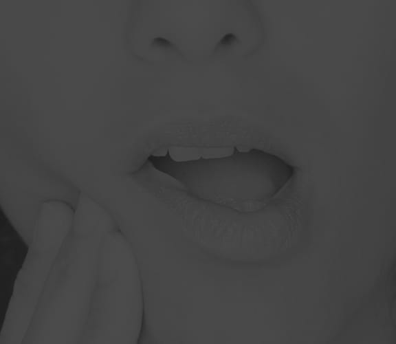 Female pushing her fingers against her cheek in pain