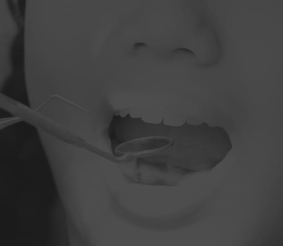 Close up of dentist using dental tools in a womans mouth